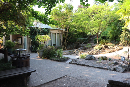 Garden space, bench and trash can near Visitor Center – stairs and ramp to parking lot Garden space, bench and trash can near Visitor Center – stairs and ramp to parking lot